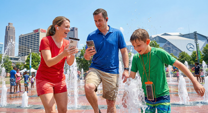 Audio tour device for Atlanta self-guided tour by Uvamai Niche Tourism, showing headphones and tour interface on a smartphone.